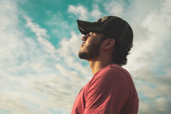 A man looking relieved in the sun with his eyes closed against a cloudy sky; in reference to the certainty that a cash sale gives