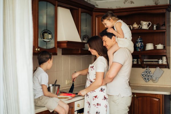 a family cooking in the kitchen, highlighting the ease of a quick home sale because of no inconvenient listings on MLS